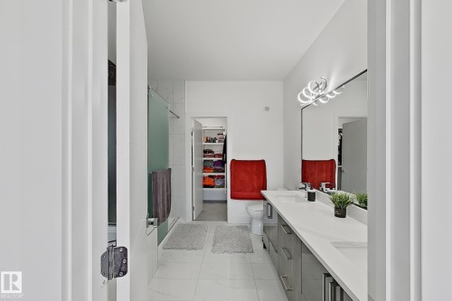 Contemporary bathroom featuring a dual vanity with white countertops and glossy gray cabinetry - 415 42 Street, Edmonton, AB 