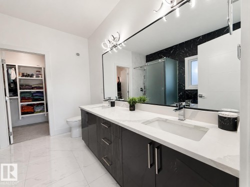 Contemporary bathroom featuring a double vanity with dark wood-finish cabinetry and white countertops - 415 42 Street, Edmonton, AB 