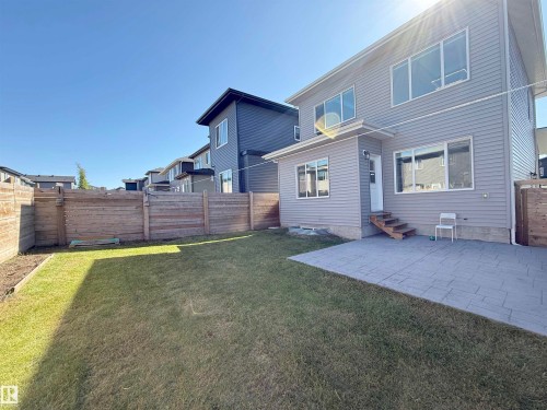 Expansive backyard featuring a manicured lawn, a stamped concrete patio, and a privacy fence - 415 42 Street, Edmonton, AB 