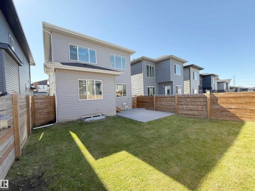Expansive backyard featuring a lush lawn, a concrete patio, and privacy fencing - 415 42 Street, Edmonton, AB 