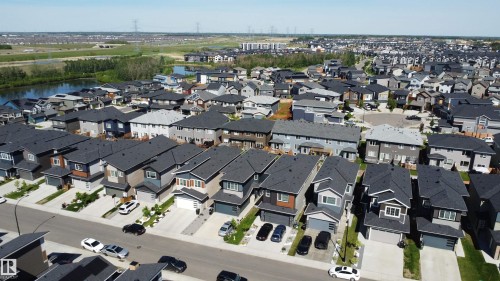 Aerial perspective of a contemporary residential development featuring multiple detached homes with dark shingle roofs - 415 42 Street, Edmonton, AB 