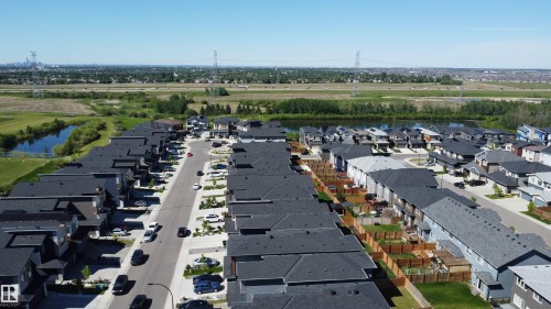 Residential development featuring contemporary townhomes with dark asphalt shingle roofs and fenced rear yards - 415 42 Street, Edmonton, AB 