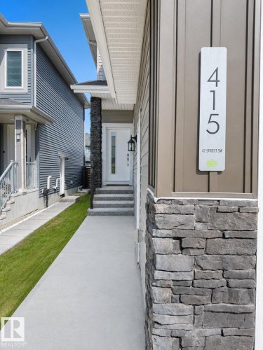 Contemporary exterior facade featuring vertical panel siding and a stone accent column - 415 42 Street, Edmonton, AB 