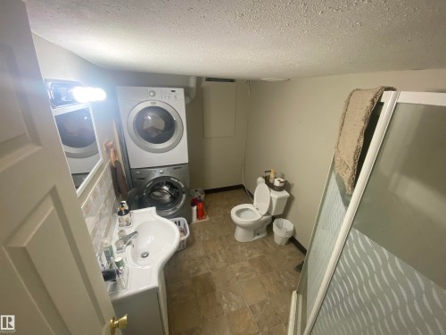 Compact bathroom featuring a shower enclosure, toilet, and vanity with a sink - 5713 44A Street, Vegreville, AB 
