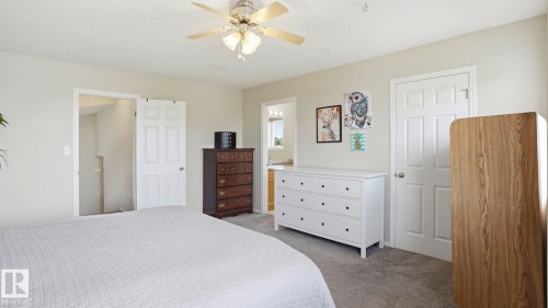 Neutral wall color, ceiling fan with integrated lighting, carpeted flooring, and white paneled interior doors - 6105 52 Avenue, Beaumont, AB 