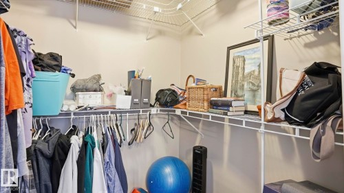 Walk-in closet featuring white wire shelving, hanging rods, and perimeter wall storage - 6105 52 Avenue, Beaumont, AB 