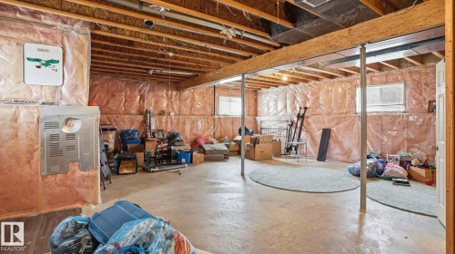 Unfinished basement featuring exposed wood joists, structural support columns, concrete flooring, and insulated perimeter walls - 6105 52 Avenue, Beaumont, AB 