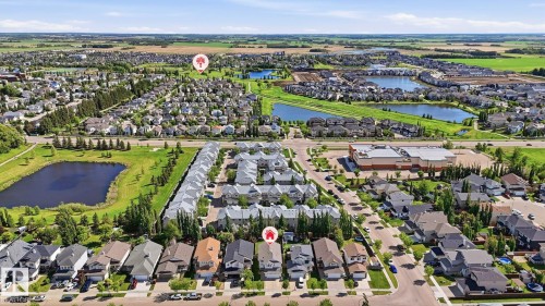 Expansive aerial perspective showcasing a residential development with multiple detached homes and townhomes - 6105 52 Avenue, Beaumont, AB 
