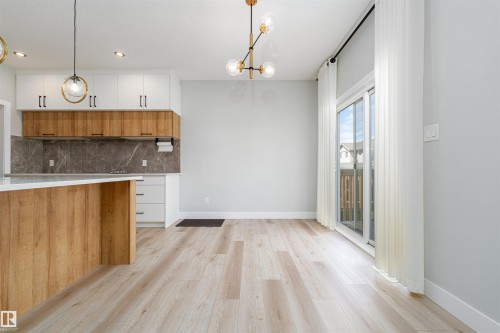 Open-concept living space with light wood-finish flooring - 17320 9 Avenue, Edmonton, AB 