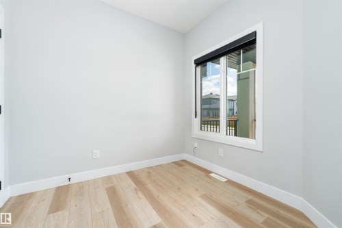 Neutral-toned walls complement wood-finish flooring - 17320 9 Avenue, Edmonton, AB 