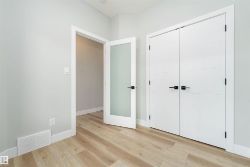 Light wood-finish flooring complements the neutral wall color - 17320 9 Avenue, Edmonton, AB 