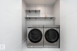 Dedicated laundry area featuring modern front-loading washer and dryer units - 