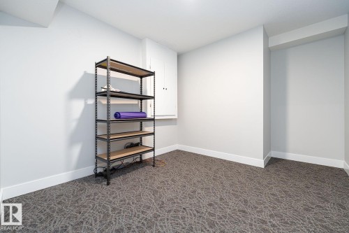 Spacious living area featuring light wood-finish flooring, recessed lighting, white baseboards, and light neutral wall tones - Edmonton, AB 