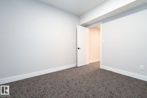 Light-filled room featuring a double window, wood-finish flooring, and white baseboards - Edmonton, AB 