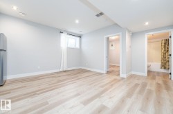 Spacious room featuring light wood-finish flooring, recessed lighting, a window with natural light, and access to a full bathroom with a shower-over-tub combination - 