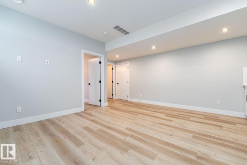 Recessed space featuring neutral-toned walls, patterned carpeting, and white baseboards - Edmonton, AB 