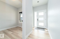 Entryway featuring a modern front door with three frosted glass panels and a full-length side light - 