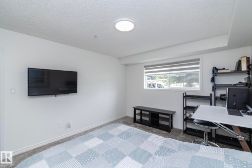 Room featuring a window with integrated blinds, a wall-mounted display, and light-colored carpet flooring - 111 182 Haddow Close, Edmonton, AB 