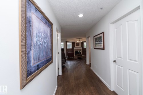 Hallway featuring wood-finish flooring, recessed lighting, and crisp white walls - 111 182 Haddow Close, Edmonton, AB 