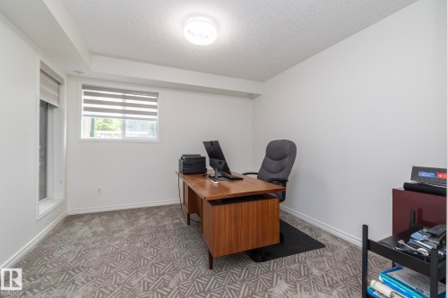 Room featuring patterned carpeting, white walls, and a contemporary flush-mount ceiling light - 111 182 Haddow Close, Edmonton, AB 