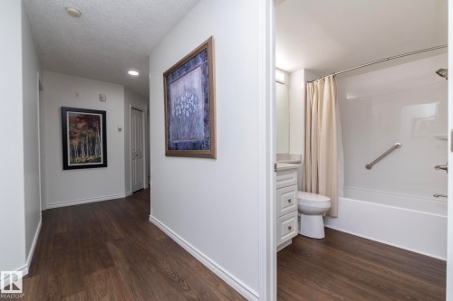 Hallway featuring wood-finish flooring and white baseboards - 111 182 Haddow Close, Edmonton, AB 
