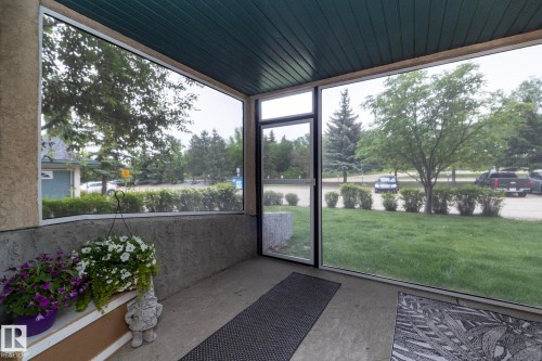 Enclosed porch featuring a concrete floor, textured stucco wall, and a wood-panel ceiling - 111 182 Haddow Close, Edmonton, AB 