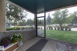 Enclosed porch featuring a concrete floor, textured stucco wall, and a wood-panel ceiling - 