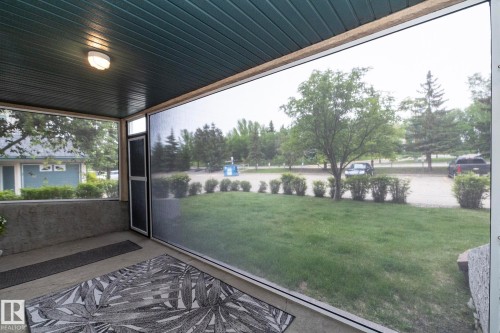 Screened porch featuring a paneled ceiling, concrete flooring, and an attached ceiling light fixture - 111 182 Haddow Close, Edmonton, AB 
