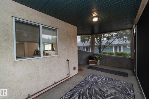 Covered patio featuring a slatted ceiling, recessed lighting, and a stucco exterior wall - 111 182 Haddow Close, Edmonton, AB 