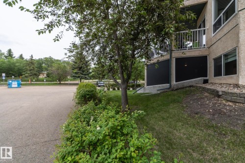 Multi-story building exterior with stucco finish and a private balcony featuring white metal railings - 111 182 Haddow Close, Edmonton, AB 