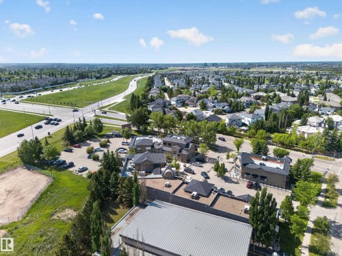 Aerial perspective showcasing commercial properties surrounded by established residential areas and green spaces - 111 182 Haddow Close, Edmonton, AB 