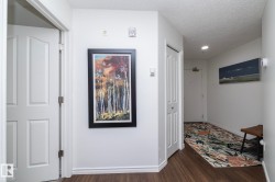 Entryway featuring wood-finish flooring, white paneled doors, and white baseboard trim - 