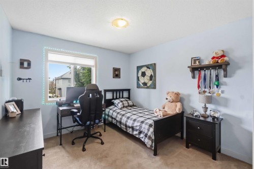 Carpeted room featuring a single window, a built-in wall shelf, light blue painted walls, and a ceiling-mounted light fixture - 20013 131 Avenue, Edmonton, AB 