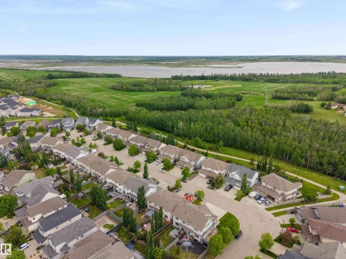 Aerial perspective of a residential neighborhood bordering expansive green spaces and a body of water - 20013 131 Avenue, Edmonton, AB 