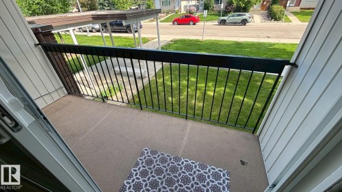 Private balcony with textured concrete flooring and black metal railing - 203 11445 41 Avenue, Edmonton, AB 