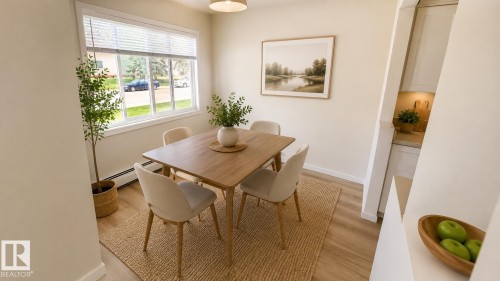 Dining area featuring wood-finish flooring, a large window with blinds, and neutral wall tones - 203 11445 41 Avenue, Edmonton, AB 