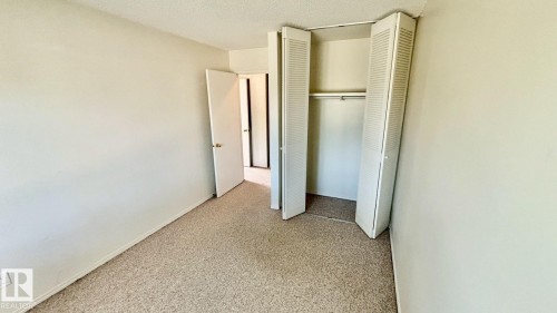 Neutral-toned walls and speckled carpet flooring define this interior space - 203 11445 41 Avenue, Edmonton, AB 