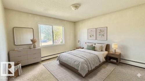 Spacious room featuring light-toned walls, a large window providing outdoor light, and textured carpeting - 203 11445 41 Avenue, Edmonton, AB 