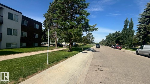 Multi-story residential building with light-colored siding and dark facade sections - 203 11445 41 Avenue, Edmonton, AB 