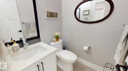 Bathroom featuring a white vanity with an integrated sink, polished chrome faucet, and quartz-finish countertop - 