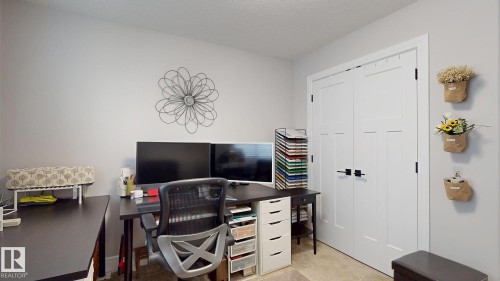 Light gray walls with white trim, featuring a pair of white double doors with black hardware - 312 West Haven Drive, Leduc, AB 