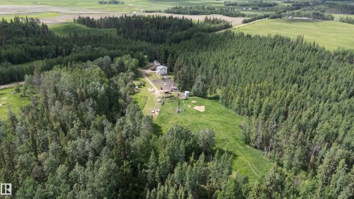 Aerial perspective showcasing a property surrounded by mature trees and expansive green spaces - 58403 Rr 60, Rural Barrhead County, AB - Outdoor With View