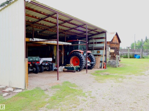 Metal-sided open-air barn structure featuring a gravel floor and exposed beam ceiling - 58403 Rr 60, Rural Barrhead County, AB - Outdoor