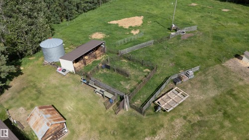 Agricultural property featuring multiple fenced enclosures, a large metal grain bin, and an open-sided barn structure - 58403 Rr 60, Rural Barrhead County, AB - Outdoor