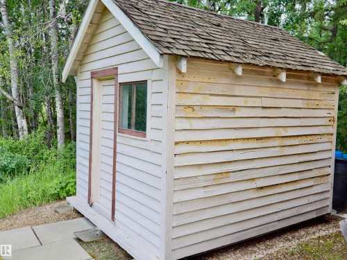 Small ancillary structure featuring wood-finish siding and a weathered shingle roof - 58403 Rr 60, Rural Barrhead County, AB - Outdoor With Exterior
