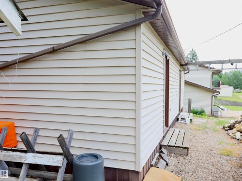 Cream-colored horizontal siding with brown trim and gutters - 58403 Rr 60, Rural Barrhead County, AB - Outdoor With Exterior