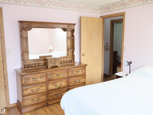 Light wood-finish flooring complements the pastel wall color - 58403 Rr 60, Rural Barrhead County, AB - Indoor Photo Showing Bedroom
