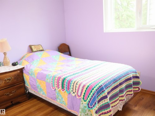 Brightly lit room featuring wood-finish flooring and a single window - 58403 Rr 60, Rural Barrhead County, AB - Indoor Photo Showing Bedroom