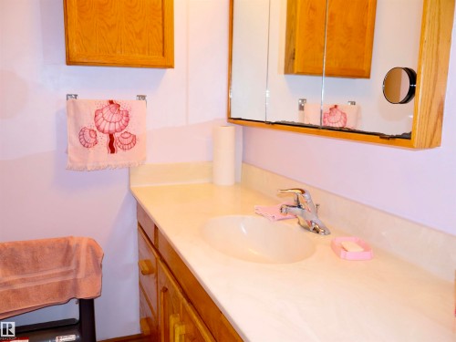 Bathroom vanity featuring a light-toned countertop with an integrated sink and chrome faucet - 58403 Rr 60, Rural Barrhead County, AB - Indoor Photo Showing Bathroom