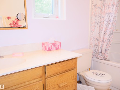 Bathroom featuring a single-sink vanity with wood-finish cabinetry and a white countertop - 58403 Rr 60, Rural Barrhead County, AB - Indoor Photo Showing Bathroom